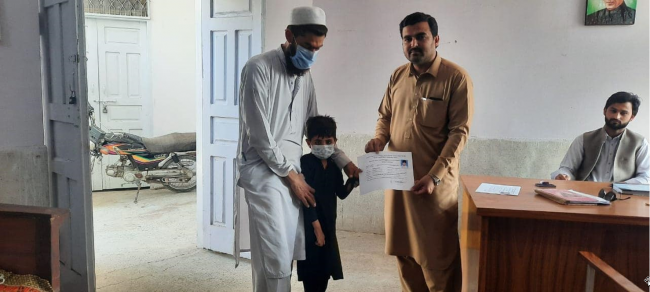A child with a disability receives his disability certificate.